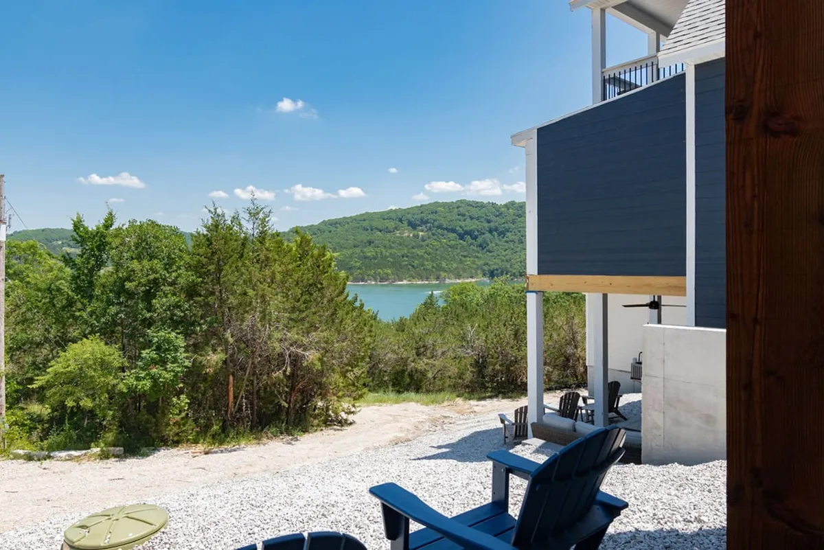 An inviting lakeside setting with Adirondack chairs overlooking tranquil Table Rock Lake, surrounded by lush greenery. The scene suggests peaceful relaxation, lakeside gatherings, and opportunities for boating or enjoying the natural setting in spring, summer, or fall.